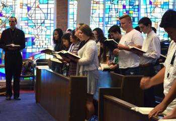 Matthew Kuna, left, diocesan seminarian, sings with the young men and women during a prayer service.