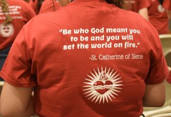 A young woman wears the Fiat Days T-shirt bearing a quote from St. Catharine of Siena.