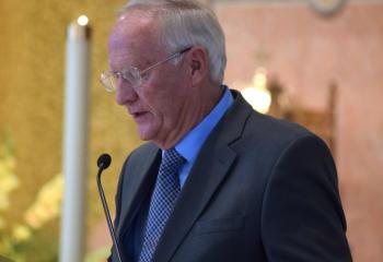 Curt Keppel proclaims the first reading at the Mass.