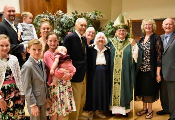The Keppel family poses with Bishop Schlert at the reception.