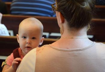 Cabrini Keppel enjoys the celebration while being held by her mother, Suzanne Keppel.