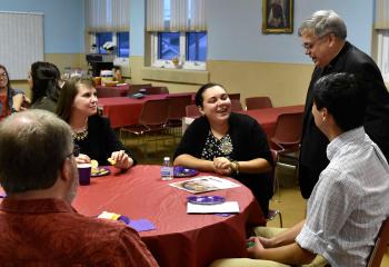 Bishop Schlert talks with young adults at the social after Vespers.
