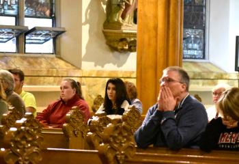 Those attending, including students from DeSales University, Center Valley, kneel in silence during Eucharistic adoration.