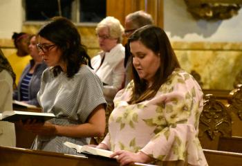 Faithful participate in Benediction during the service.