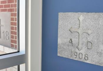The cornerstone of the new parish, left, is affixed to the exterior of the center, and the cornerstone of the original church to the interior.