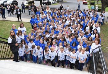 Students wearing their Cougar Crawl T-shirts join with the faculty and family members attending the blessing.