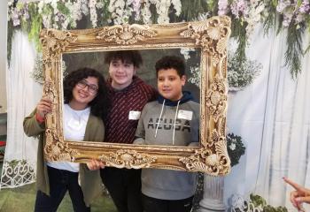 Members of the Alvarenga family enjoy the photo area as a family. / Jóvenes de la familia Alvarenga disfrutan en el área de fotografías con la familia.  (Photo by Bernarda Liriano)