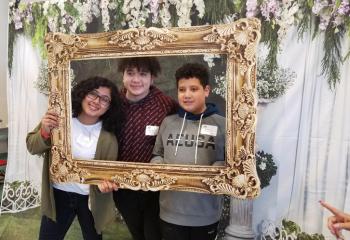 Members of the Alvarenga family enjoy the photo area as a family. / Jóvenes de la familia Alvarenga disfrutan en el área de fotografías con la familia.  (Photo by Bernarda Liriano)