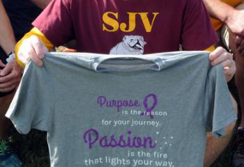 Mike Romanic, who coaches the cross country team from St. John Vianney Regional School, Allentown, shows the shirt he received during the event for his 21 years of coaching. (Photo by Ed Koskey)