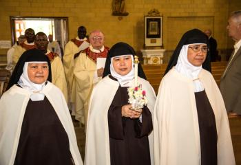 Processing into the ceremony are, from left, Carmelite Sisters Mother Teresa Margarita, Sister Monica and Sister Arlene Marie.