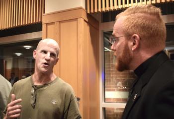 Lawton, left, chats with Father Mark Searles, director of the Diocesan Office for Vocations Promotion and chaplain of Allentown Central Catholic High School, during the dessert reception.