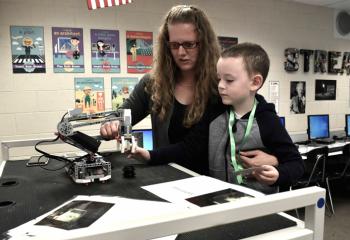 Maribeth Johns, left, first grade teacher, shows Jackson Pemrick how to operate one of the new robots.