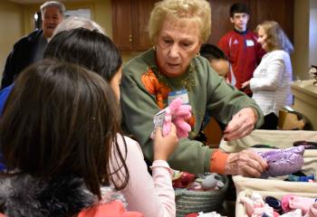 Volunteer Doris Marsicano finds hats and gloves for some of the children.