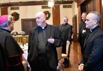 Bishop Schlert, left, talks with Monsignor Joseph DeSantis and Deacon Juan Eduardo Rodriguez. In back are Father Thomas Bortz, left, and Father Donald Cieniewicz.