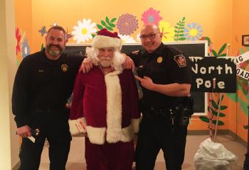 Police officers James Stanko, left, and Matt Geake with Santa at the North Pole.