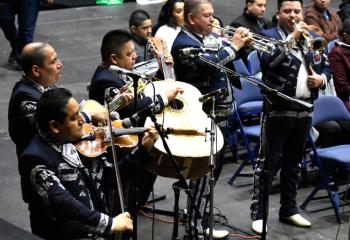 The mariachi band plays. / La banda de mariachis toca.