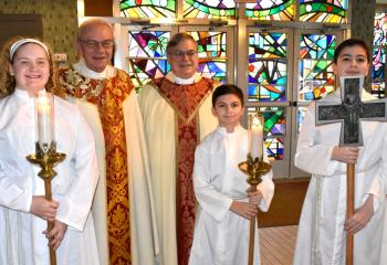 Bishop Schlert, center, with altar servers and Father Joseph Tobias, pastor.