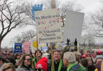 Father Marty Kern carries the St. Columbkill Parish, Boyertown sign. (Photo courtesy of Candee Holzman)