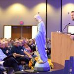 Fr. Michael Gaitley, a member of the Congregation of the Marian Fathers of the Immaculate Conception, talks about Our Lady of Guadalupe and Our lady of Fatima beside a statue of the Blessed Mother.