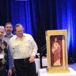 Deacon Campanell, right, awards a statue of the Sacred Heart of Jesus to men from St. Benedict, Mohnton for having the highest attendance percentage.