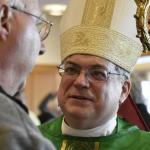  Bishop Schlert greets a conference participant after Mass.