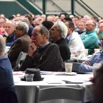 Men listen to the speakers.