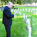 The Most Rev. Edward P. Cullen, D.D., Bishop of Allentown, prays at the Wernersville grave of the Rev. Walter J. Ciszek Oct. 6, 2003. Examining the grave was a step toward the cause of Fr. Ciszek’s canonization.