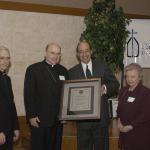 Council on Accreditation President and Chief Executive Officer Richard Klarberg, third from left, presents the COA accreditation plaque for Catholic Charities, Diocese of Allentown to Bishop Cullen. Joining Klarberg and the bishop at the Feb. 1, 2006 reception at St. Thomas More, Allentown are the Rev. Msgr. Walter T. Scheaffer, President of the Catholic Charities Board of Directors, left, and Barbara W. Murphy, M.S.W., diocesan Secretary for Human Services and Executive Director of Catholic Charities.