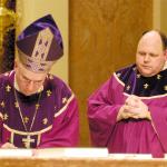 The Most Rev. Edward Cullen, D.D., left, Bishop of Allentown, signs a decree promulgating 27 statutes at the Cathedral of St. Catharine of Siena, Allentown Dec. 10, 2006. Witnessing the historic moment is the Rev. David L. James, right, General Secretary of the Synod.